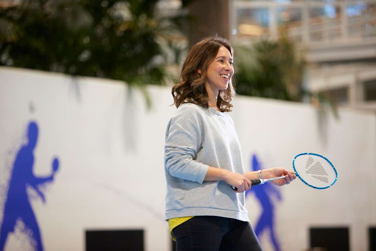 A lady smiling with a badminton racket