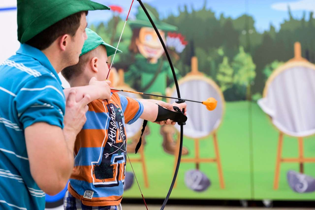 A little boy aiming an arrow