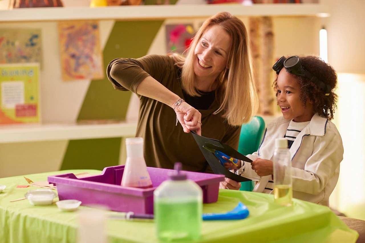 Achild and parent sat round a craft table taking part in the activity.
