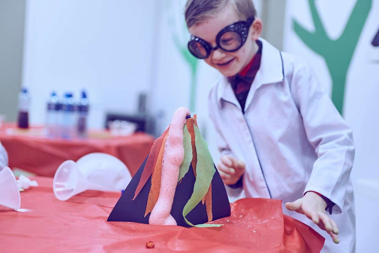 A little boy looking over an exploding volcano.