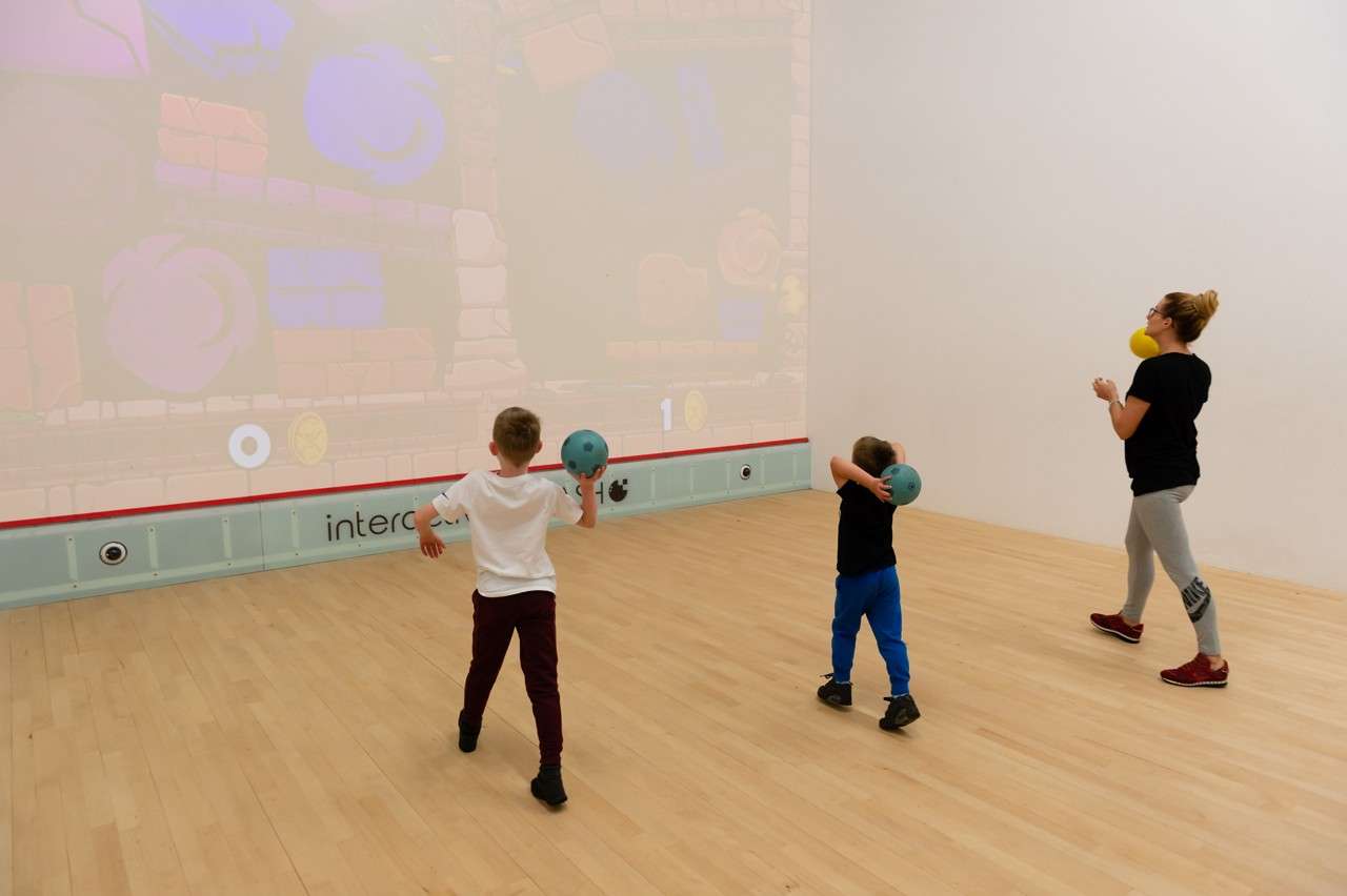 Children throwing balls at the wall