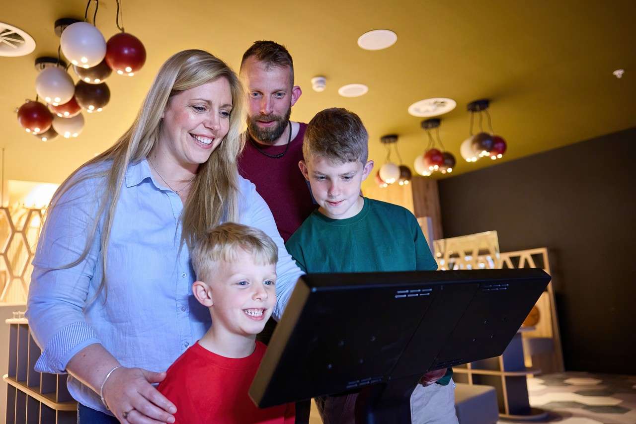 A family looking over the bowling screen 