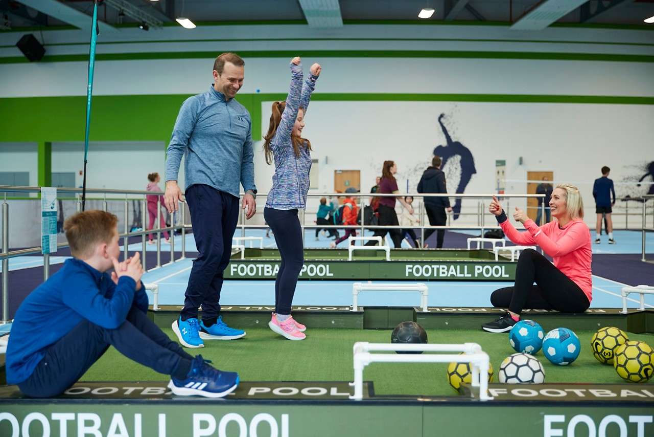 A little girl celcbrating when her ball gets in the net