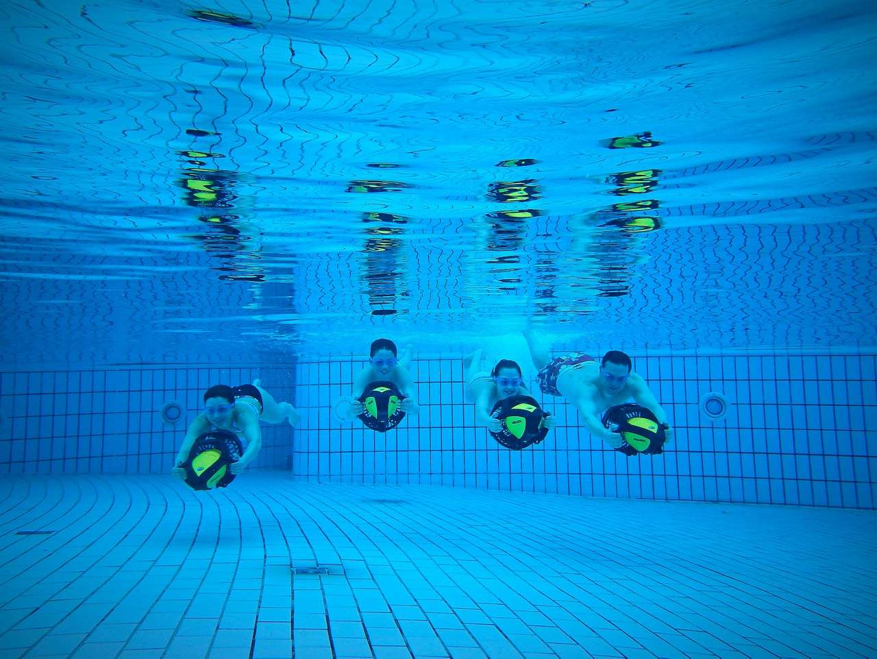 A family lined up together under the water. 