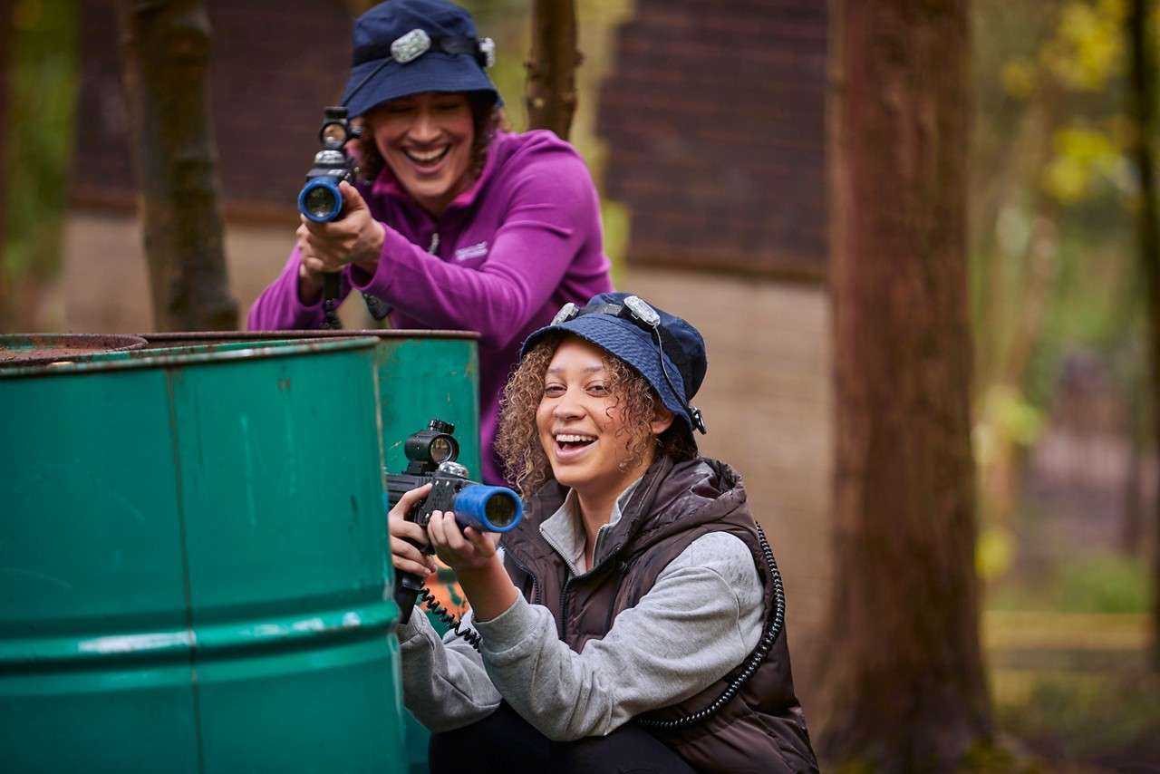 A girl hiding for protection behind a steel barrel. 