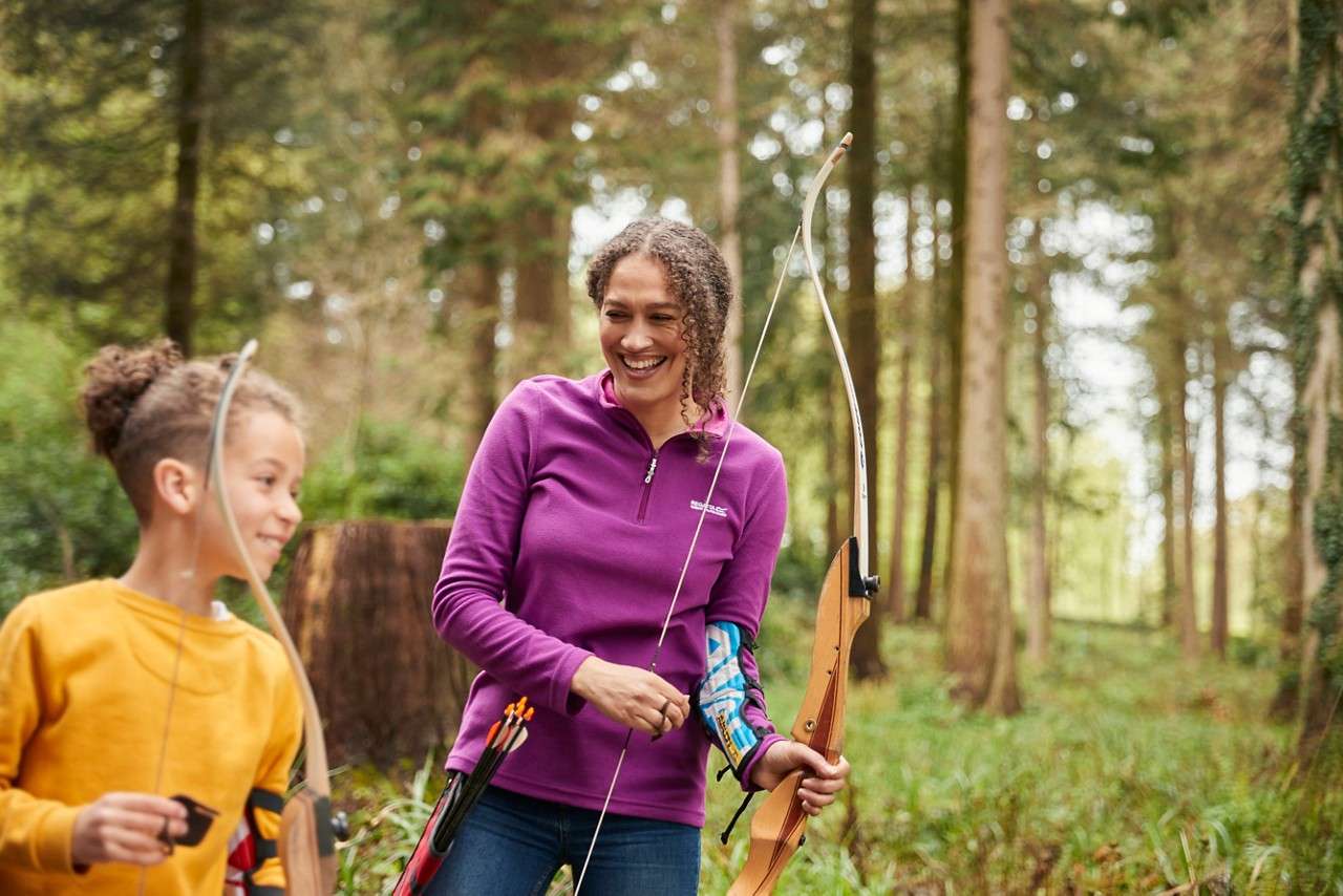 Mum smiling looking at son with bow and arrows.
