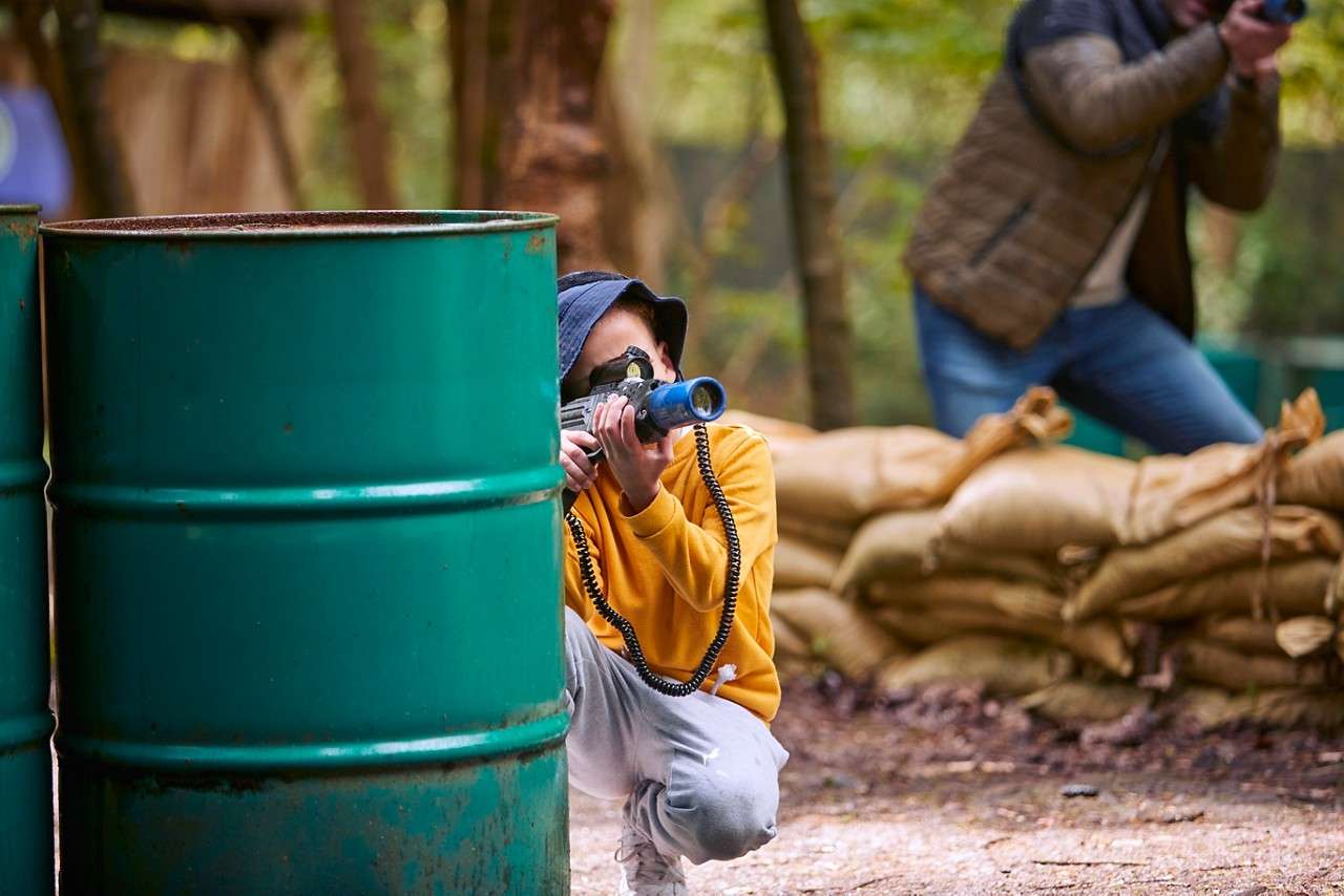 A boy hiding behind a barrel
