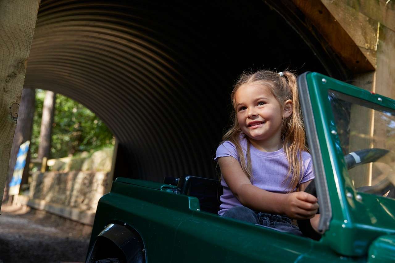 A little girl driving through a tunnel