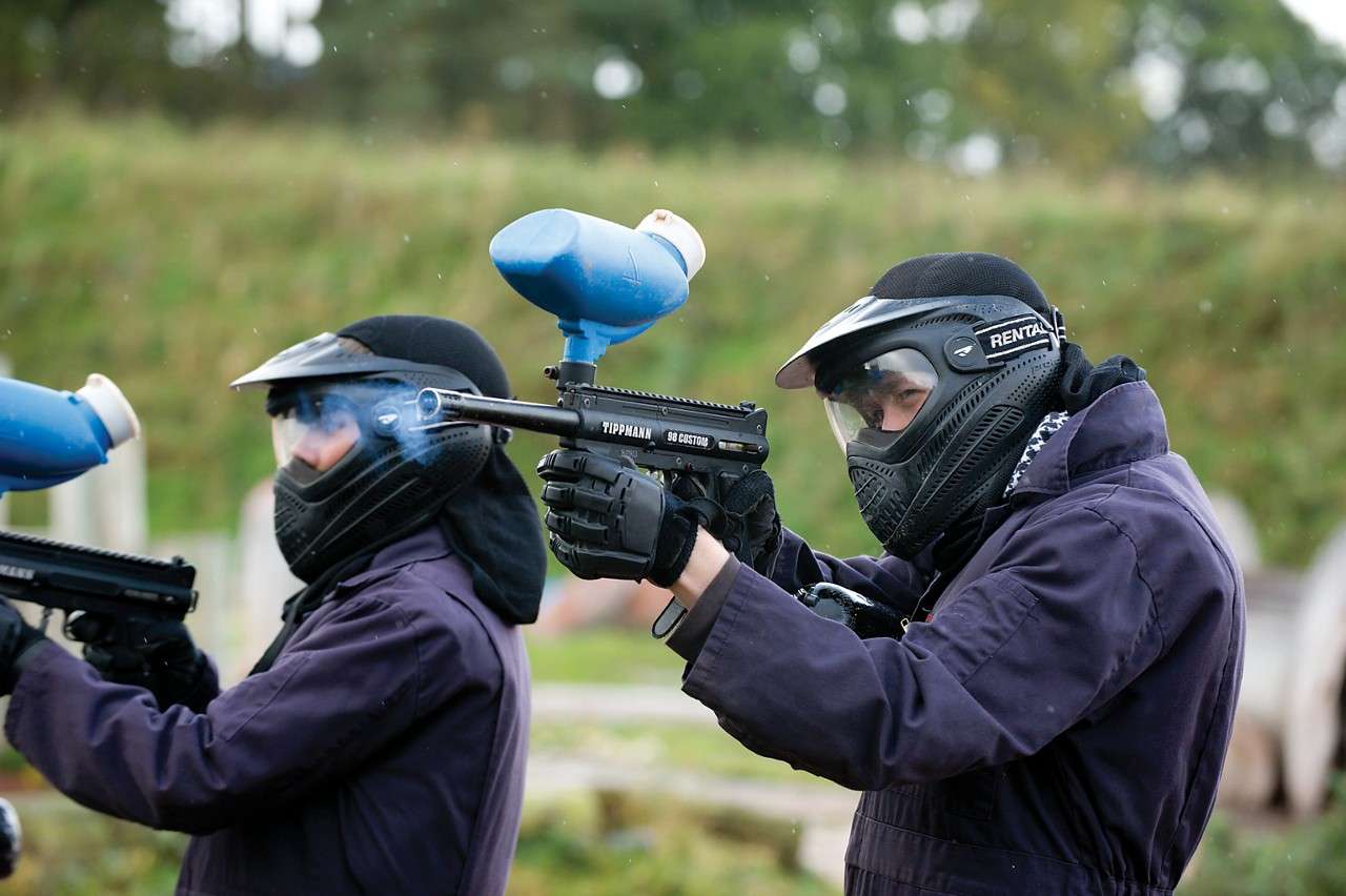People in paintballing outfits taking aim