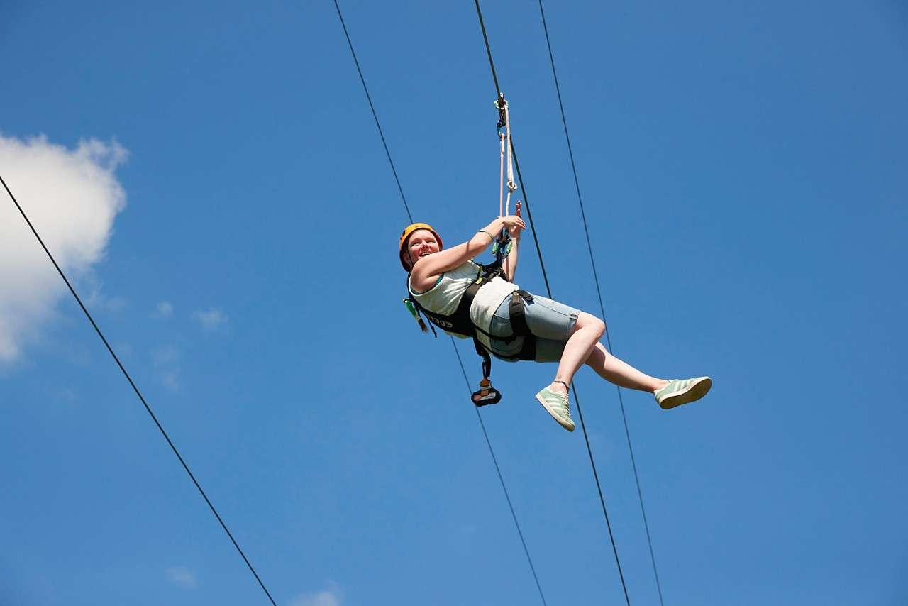 Two people flying down the zip line