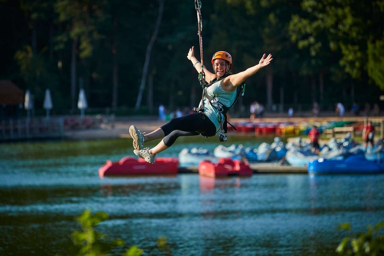 A lady with her arms out on the zip line