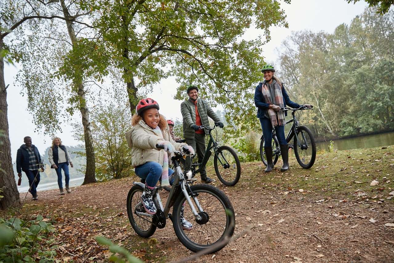 Family riding bikes through the forest.
