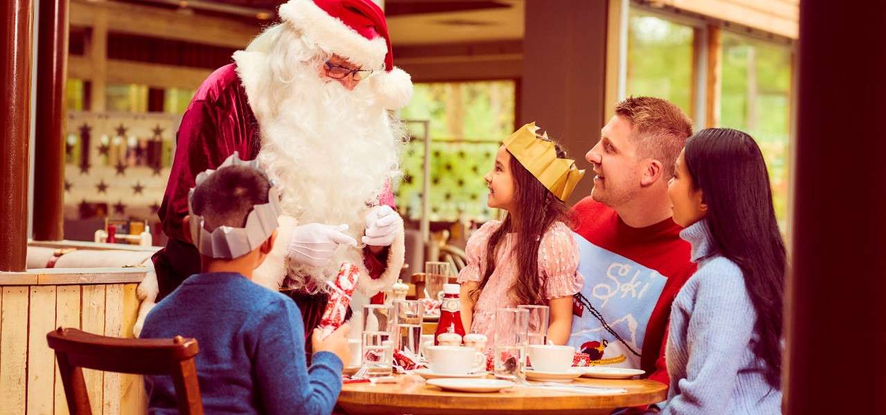 Family sitting round a table having brunch whilst Santa visits