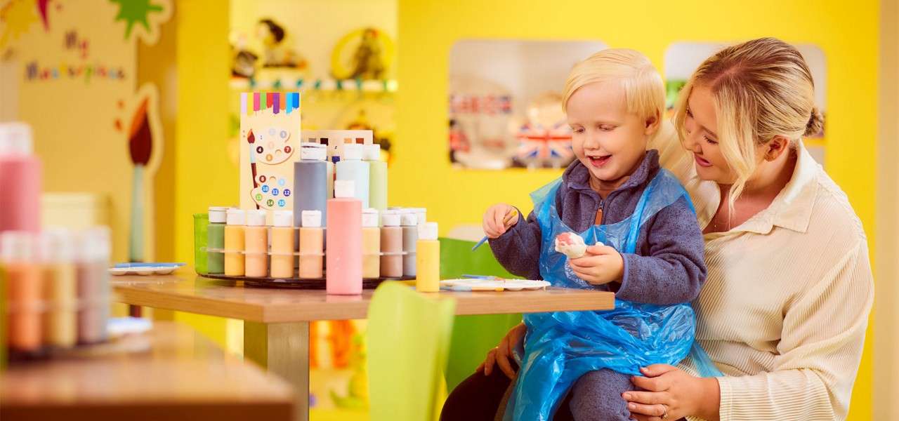 Young boy painting an elf pot