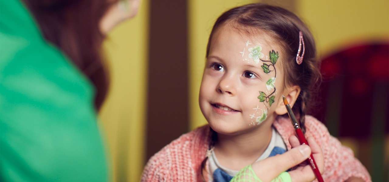 Young girl having her face painted 