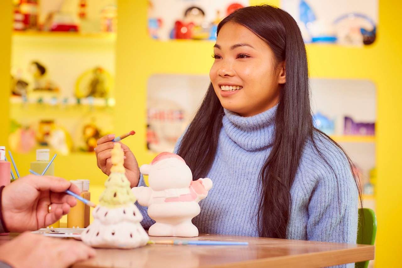 A young girl painting a christmas tree.