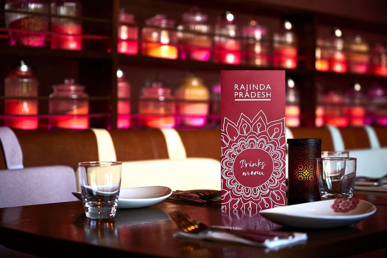 Inside of the Rajinda restaurant with tables and chairs lined up.