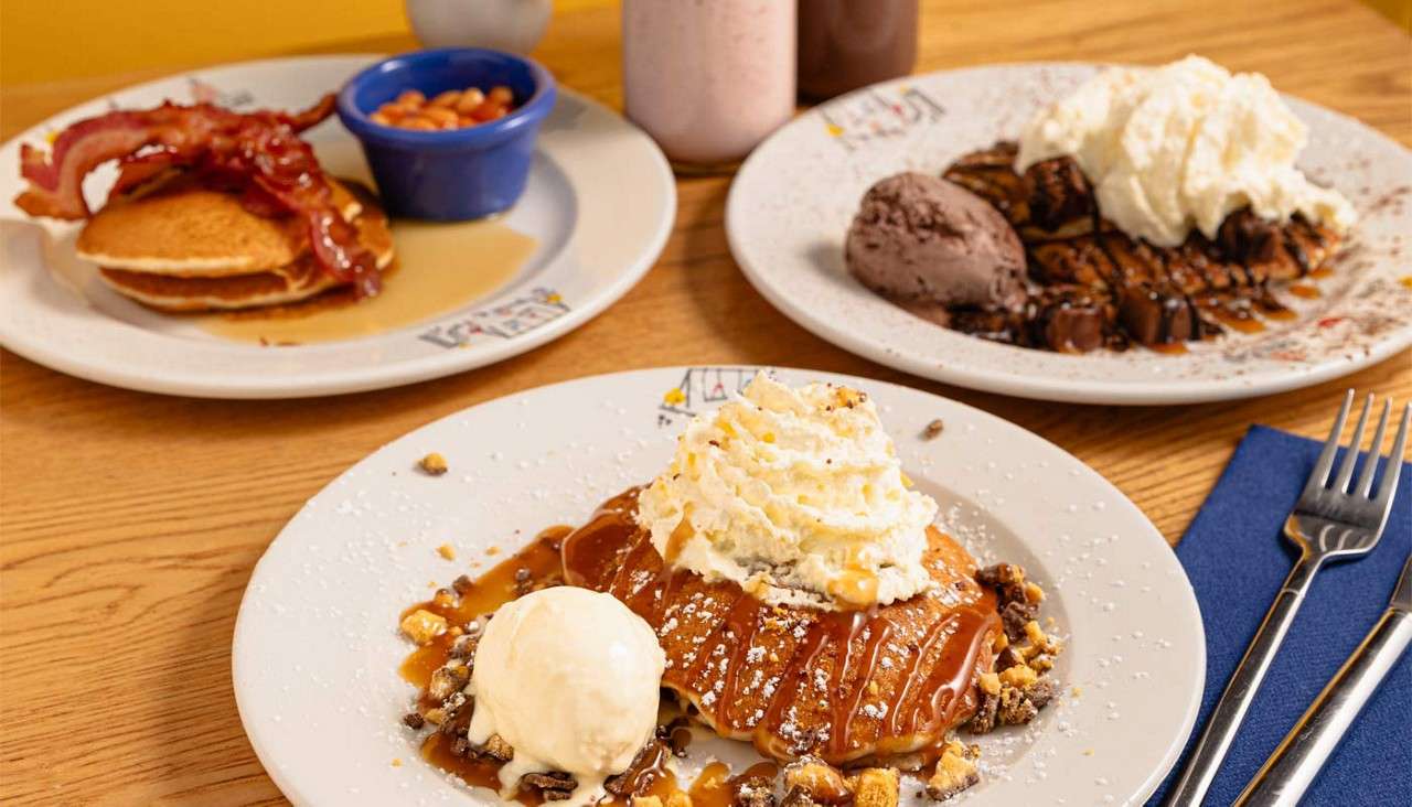 Stacked pancakes topped with a variety of toppings.