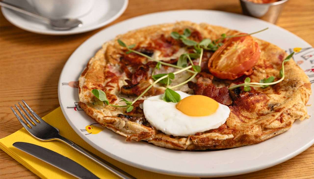 Omelette topped with breakfast items.
