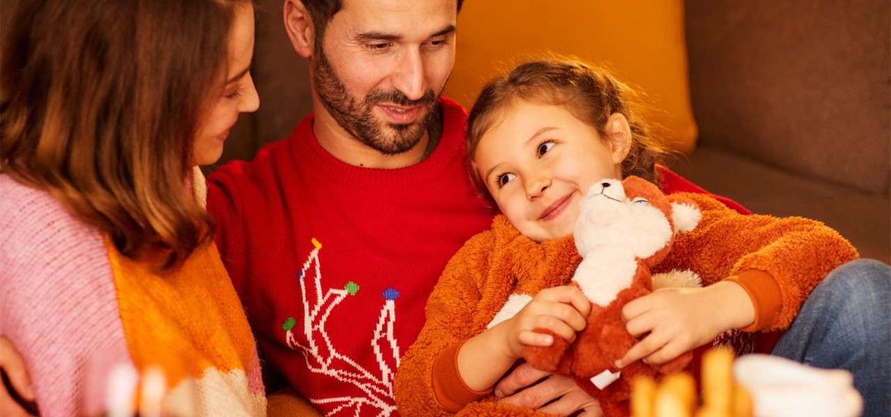 Woman, man and girl holding a soft toy