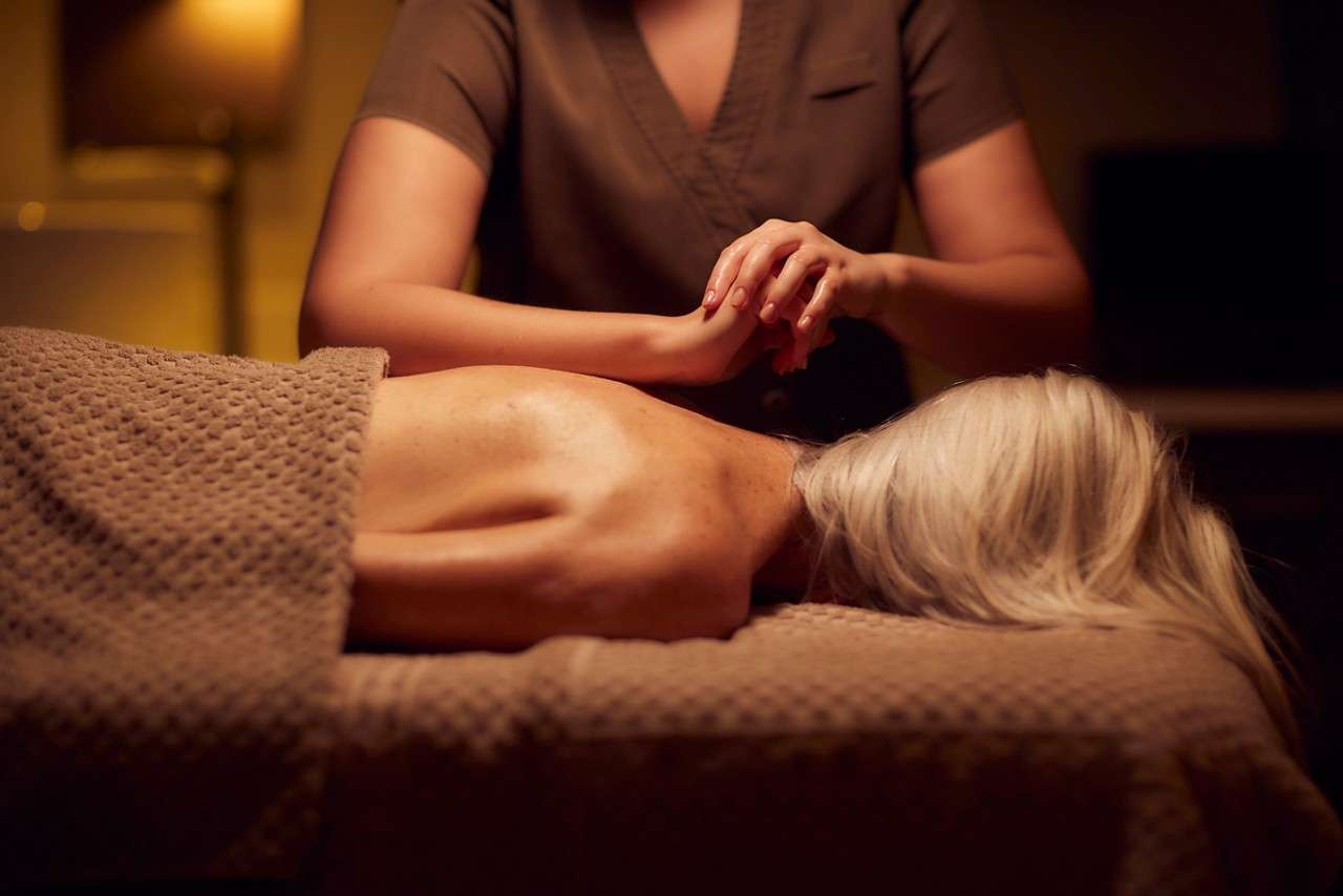 Spa therapist giving a woman a body massage treatment.