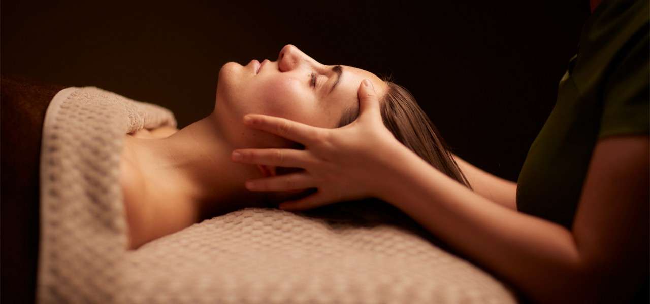Spa therapist giving a women a relaxing face and body treatment.