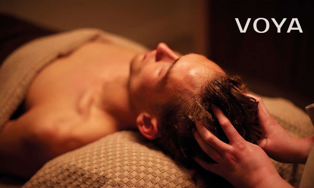 a man testing on a spa bed having a scalp massage