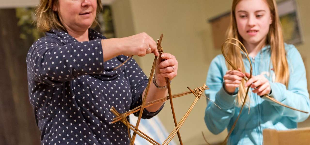 A mother and daughter weaving willow