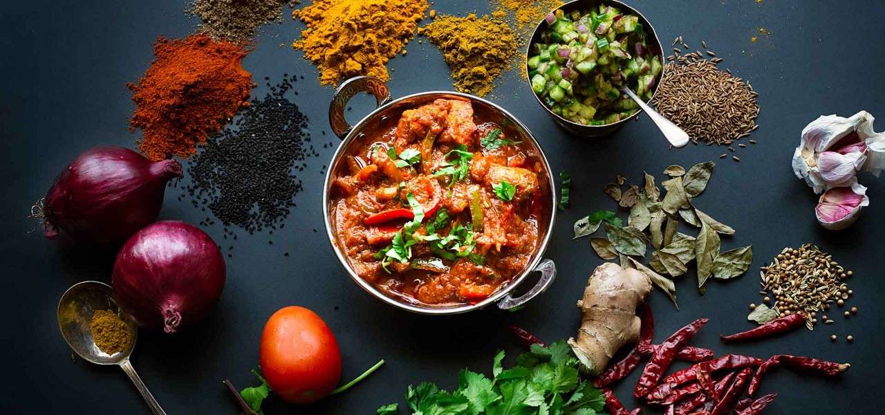 Curry in a dish with ingredients all around it