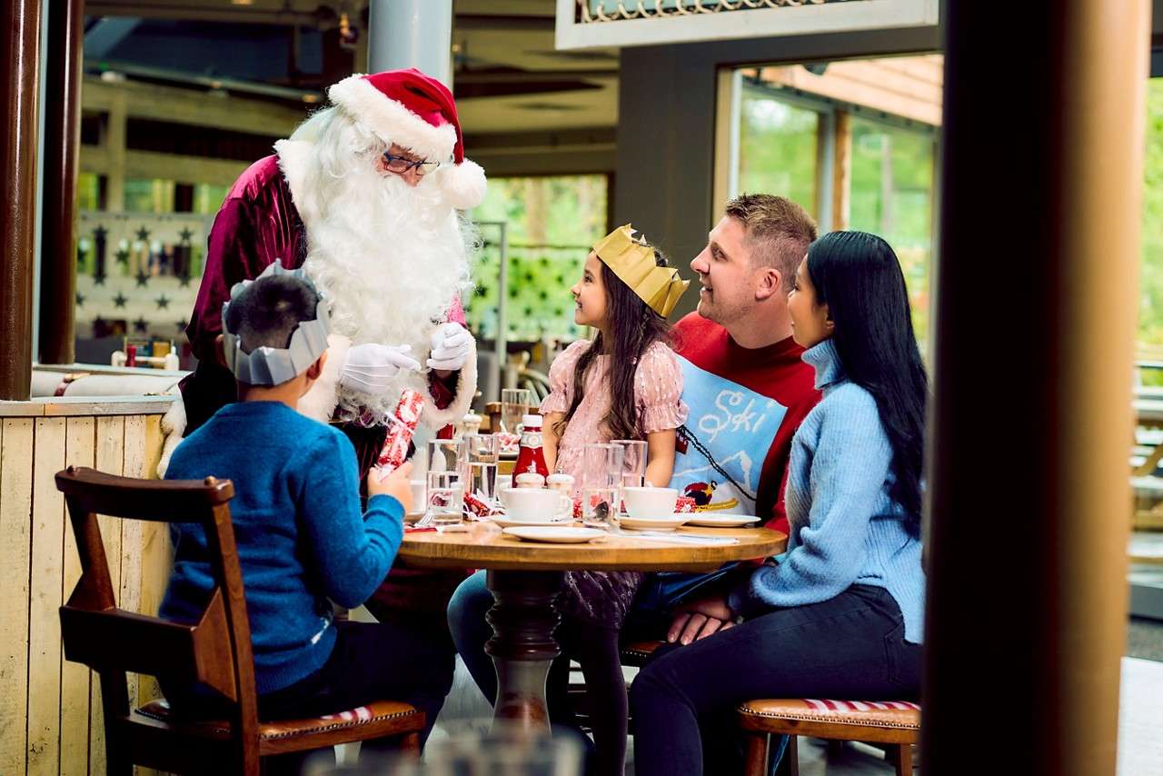 Family sitting a table whilst Santa comes to visit.