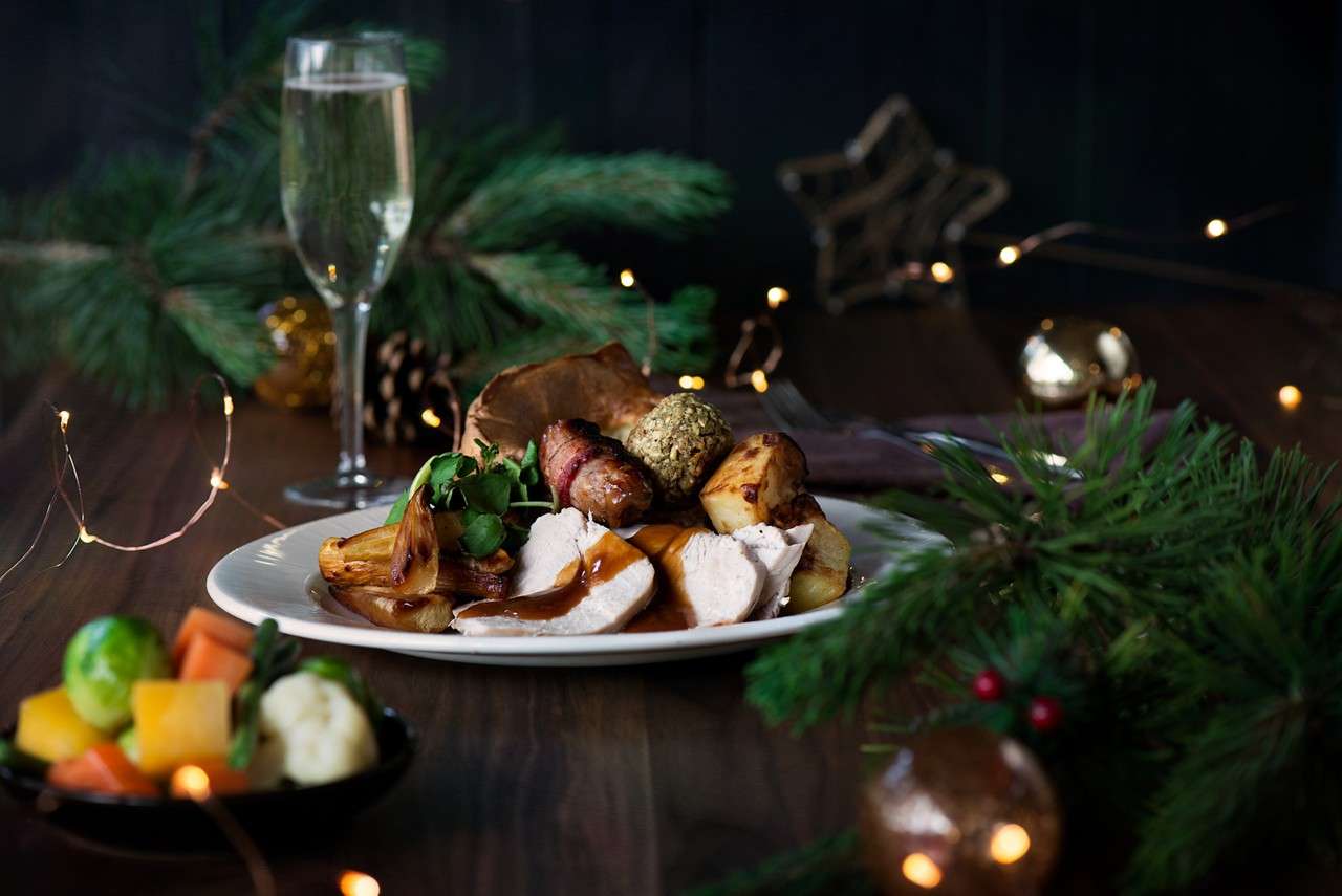 Christmas dinner topped with gravy and served with seasonal vegetables.