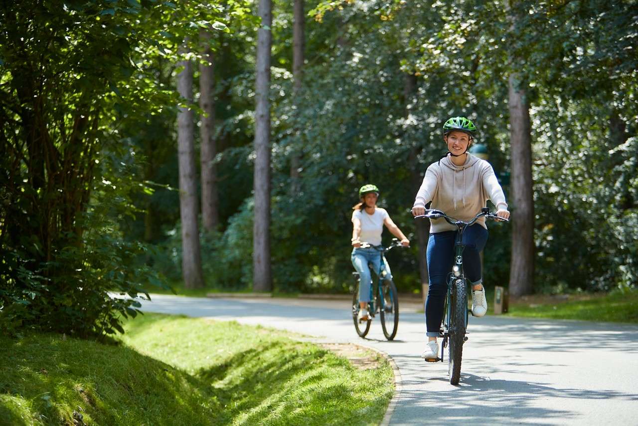 Ladies cycling through the forest.