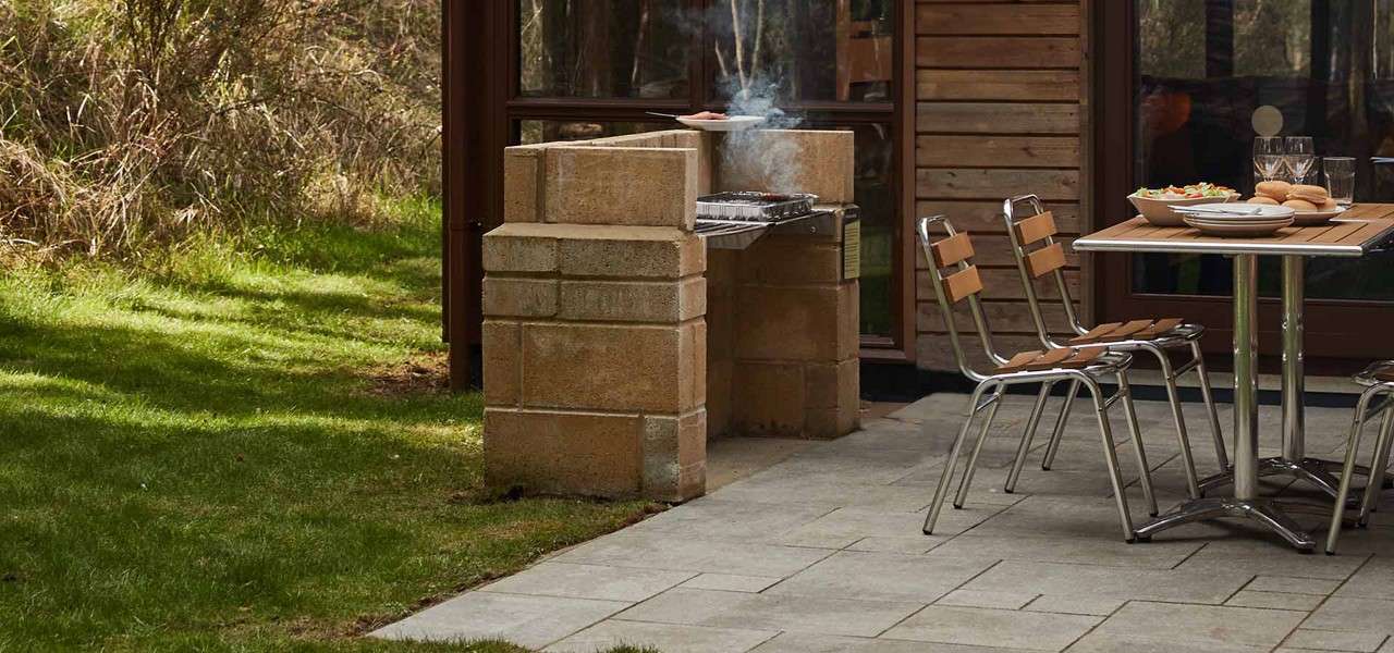Outdoor table and chairs on a patio with food arranged nicely.