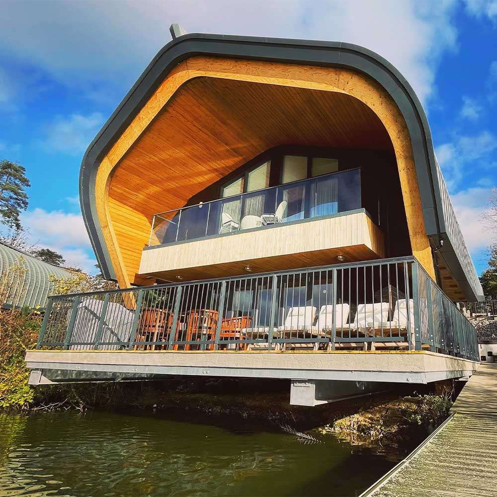 A close up exterior shot of the Waterside Lodges at Elveden Forest.