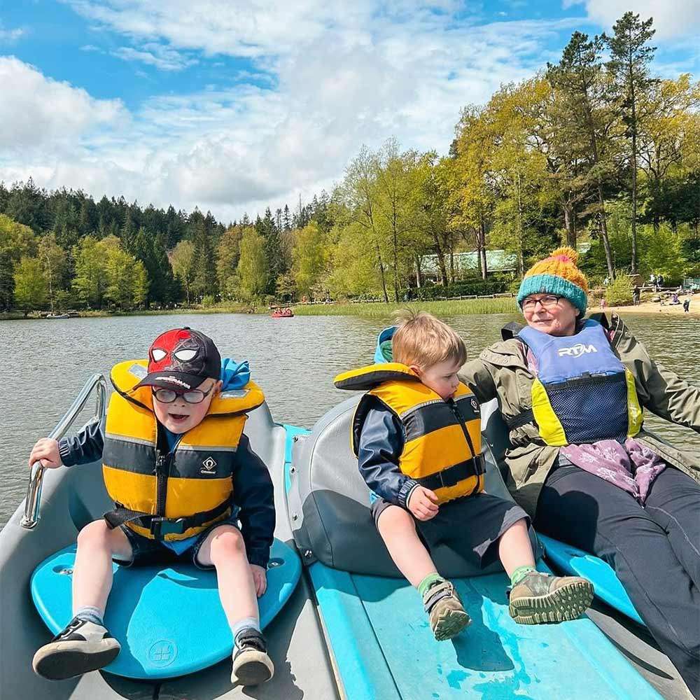A family sat in a pedalo on the lake on a sunny day.