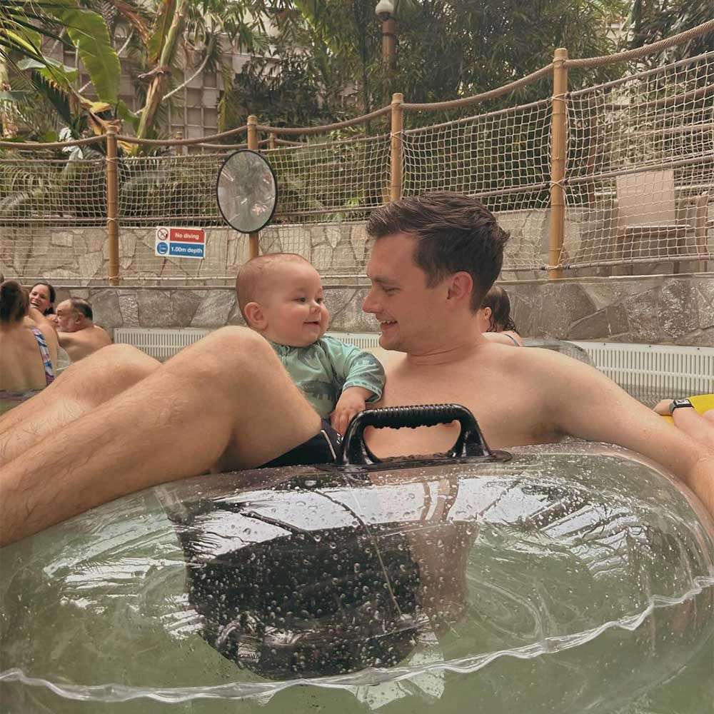 A parent and their baby in an inflatable donut in the Subtropical Swimming Paradise.