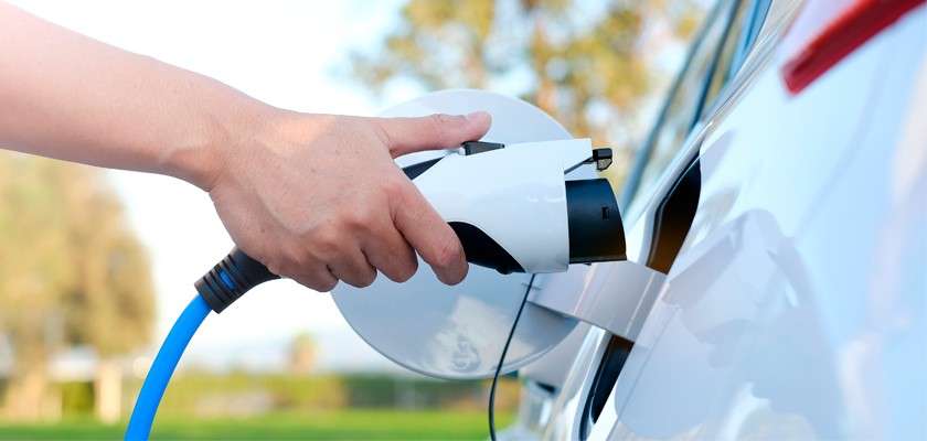 Person plugging in their electric car into an EV charger.