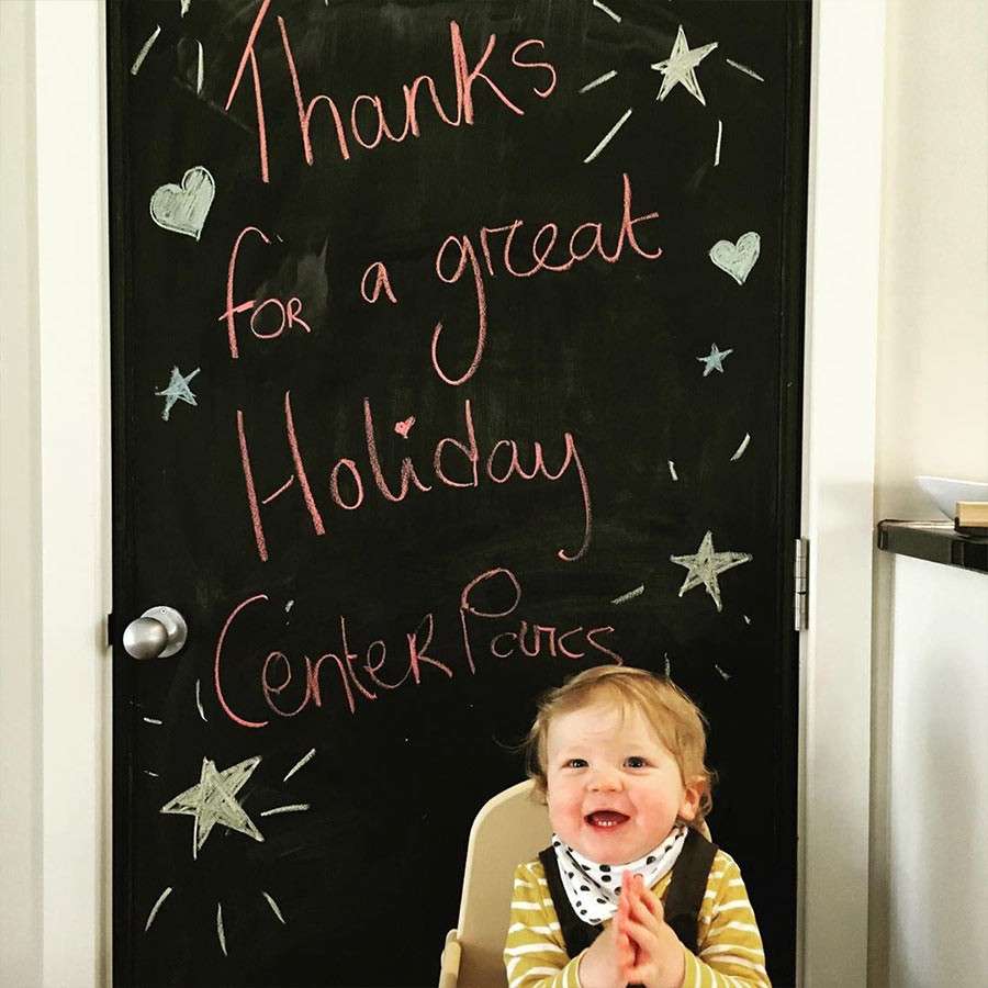 Toddler laughing in front of Thank You sign