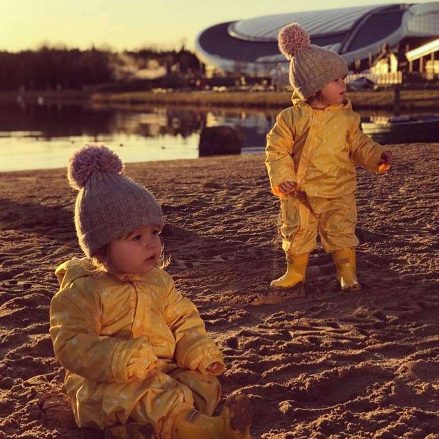 Twin toddlers play on the beach