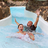 Dad and daughter riding down the wild water rapids.