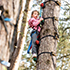 Girl in tree tops on aerial adventure