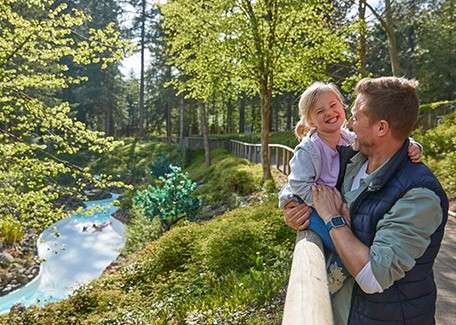 A father and daughter overlooking the rapids at springtime