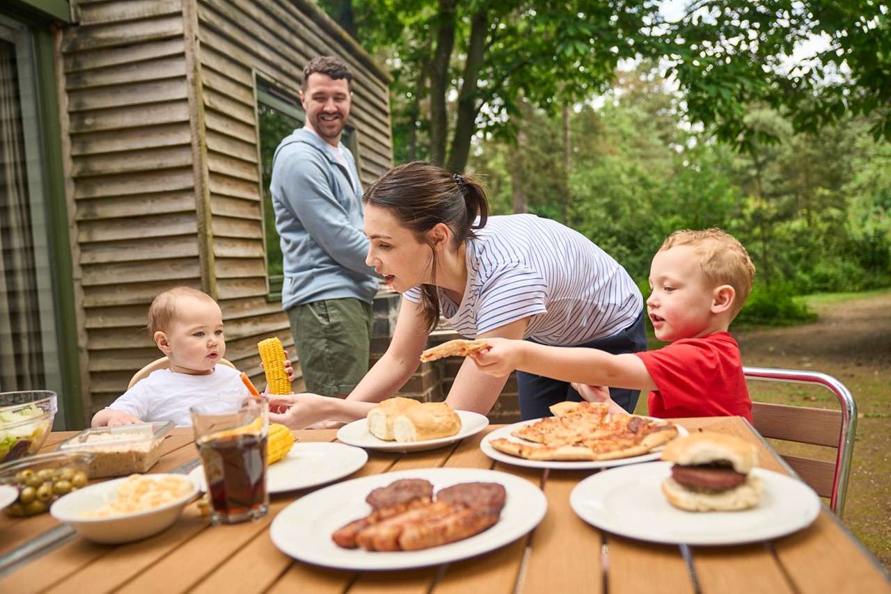A family having a barbecue outside their lodge.
