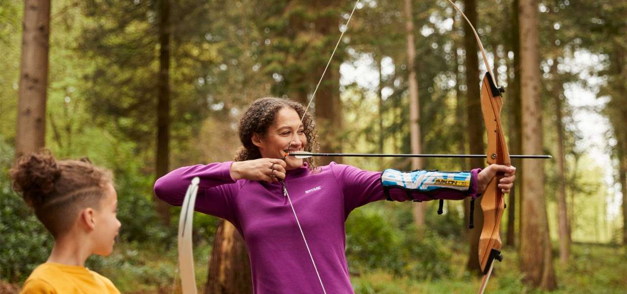 A girl aiming at a target with her bow and arrow.