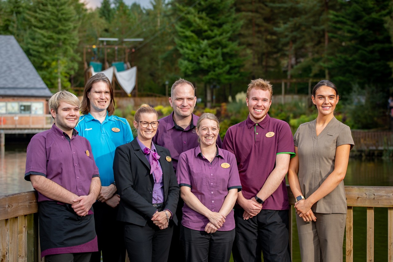 A group of staff members in front of the lake