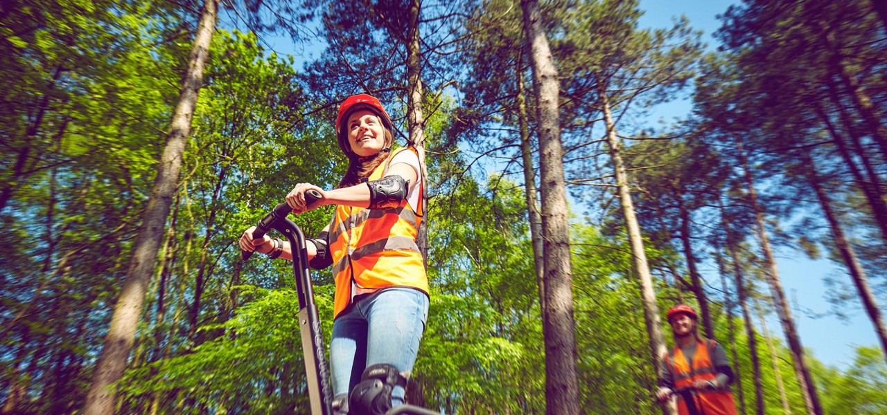 A woman driving a segway through the forest